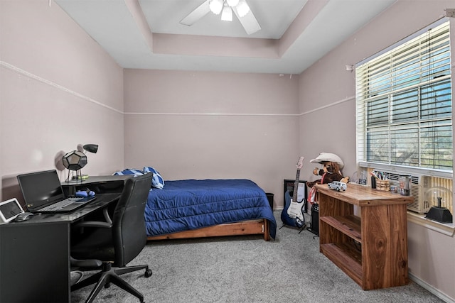 bedroom with light carpet, a raised ceiling, and ceiling fan