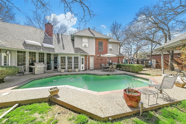 view of swimming pool featuring grilling area and a patio