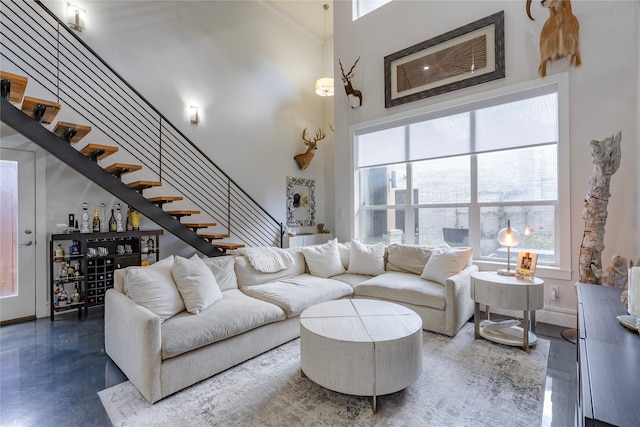 living room with concrete flooring and a high ceiling