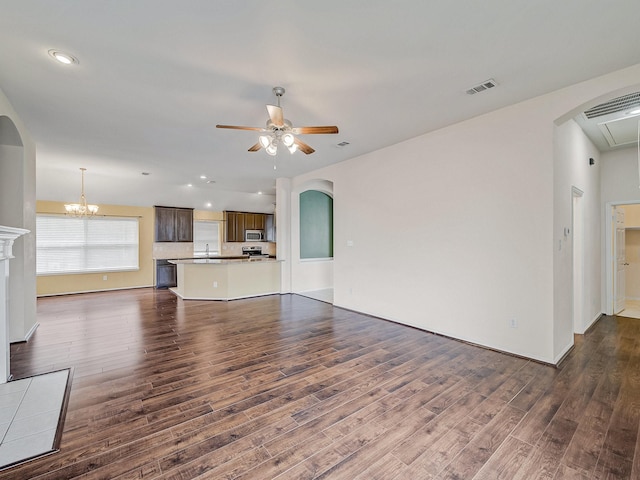 unfurnished living room with dark hardwood / wood-style floors and ceiling fan with notable chandelier