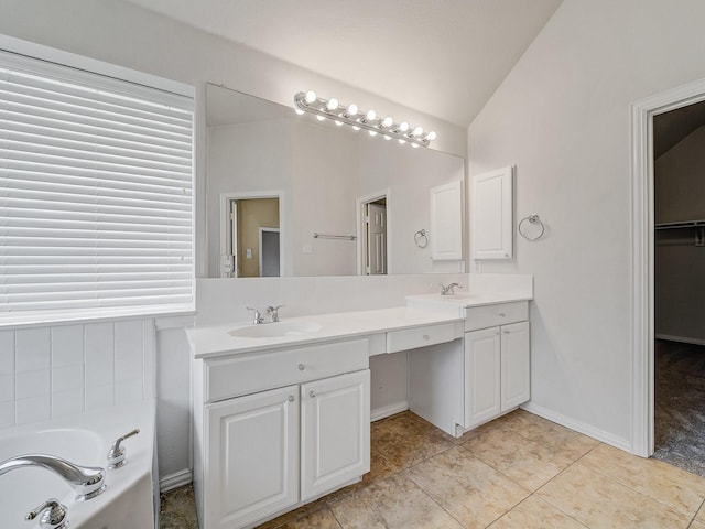 bathroom featuring vanity, tile patterned flooring, a washtub, and lofted ceiling