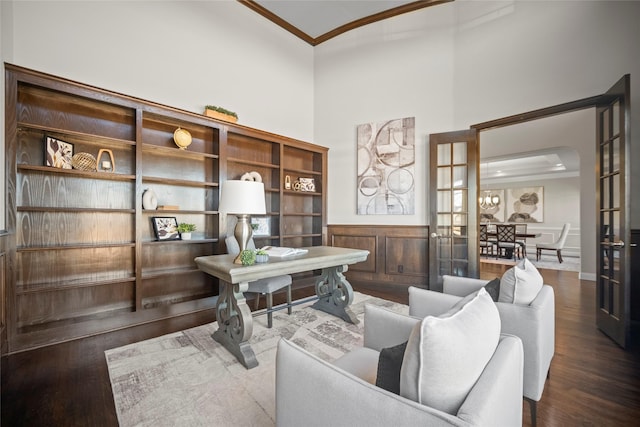 office featuring french doors, ornamental molding, dark hardwood / wood-style floors, and a towering ceiling