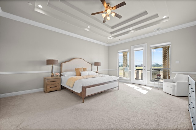 carpeted bedroom featuring ornamental molding, access to exterior, ceiling fan, and a tray ceiling