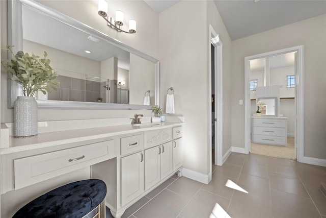 bathroom featuring tile patterned flooring, vanity, and a shower