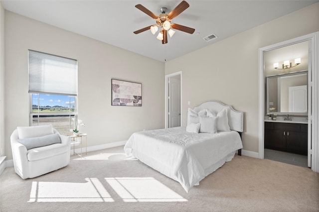 carpeted bedroom featuring ceiling fan, ensuite bathroom, and sink