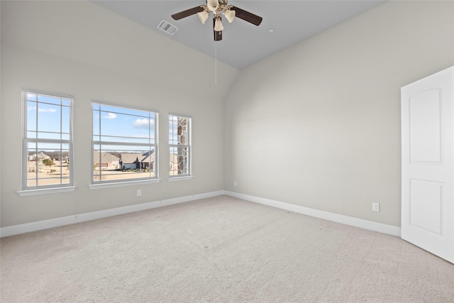 empty room featuring vaulted ceiling, light colored carpet, and ceiling fan