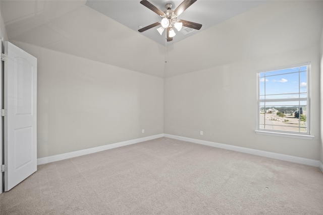 empty room featuring vaulted ceiling, light colored carpet, and ceiling fan