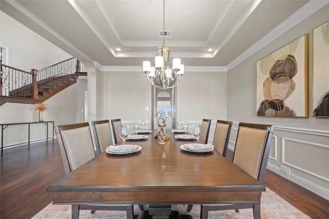 dining space with a raised ceiling, an inviting chandelier, and dark hardwood / wood-style flooring