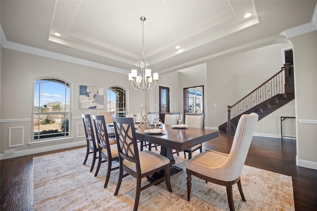 dining room with a raised ceiling, hardwood / wood-style flooring, and a notable chandelier