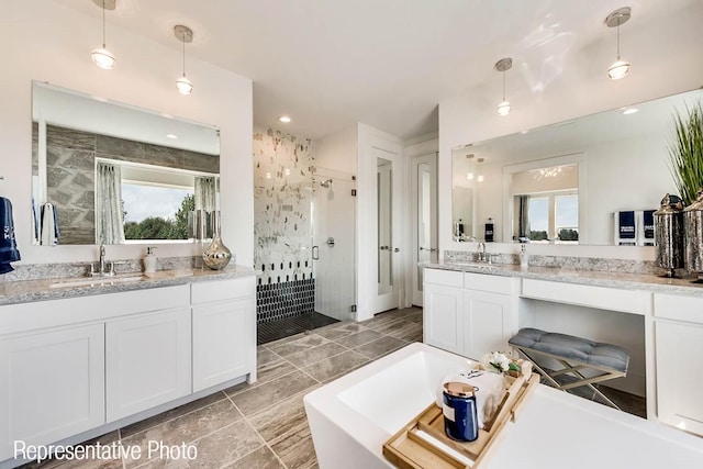 full bath with a sink, a freestanding bath, two vanities, and a shower stall