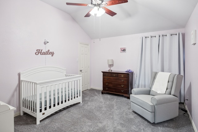 carpeted bedroom featuring ceiling fan, vaulted ceiling, and a crib