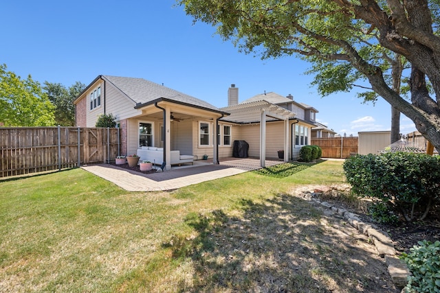 rear view of property featuring a pergola, a patio area, ceiling fan, and a lawn