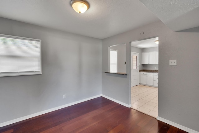 spare room featuring a textured ceiling and light wood-type flooring