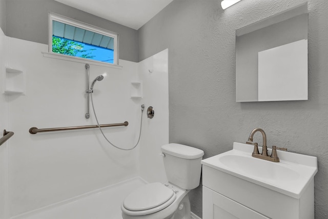 bathroom featuring vanity, a shower, and toilet