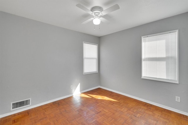 spare room featuring parquet flooring and ceiling fan