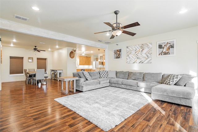 living room featuring dark wood-type flooring, visible vents, a ceiling fan, and recessed lighting