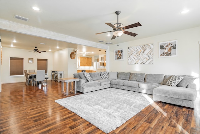 living room with dark wood-type flooring and ceiling fan