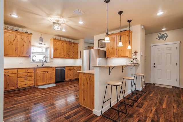 kitchen with sink, a kitchen breakfast bar, kitchen peninsula, pendant lighting, and stainless steel appliances