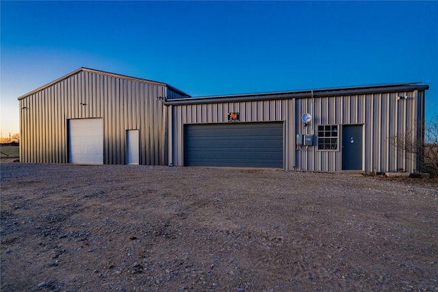 view of garage at dusk