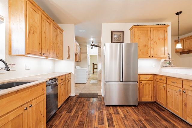 kitchen with washer and dryer, pendant lighting, sink, dark hardwood / wood-style flooring, and stainless steel appliances