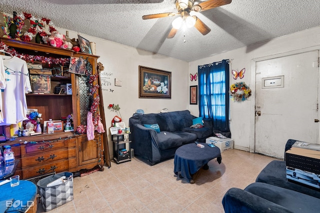 living room with ceiling fan and a textured ceiling