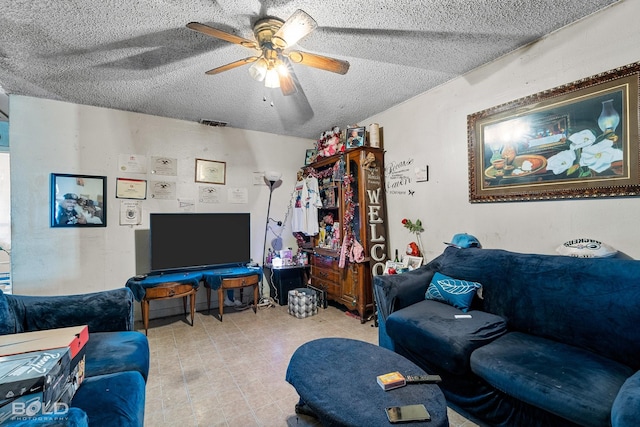 living room with ceiling fan and a textured ceiling