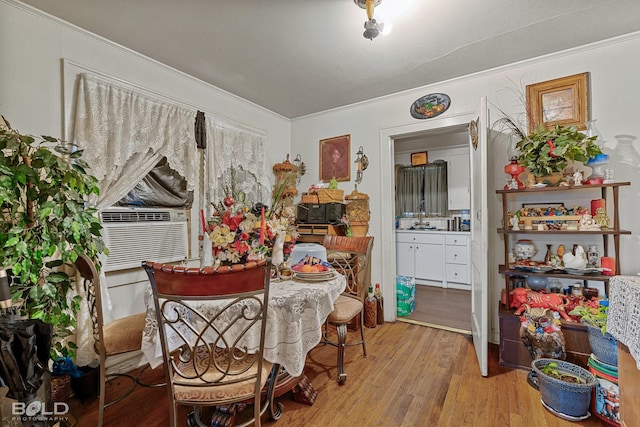 dining room featuring crown molding, light hardwood / wood-style floors, and cooling unit