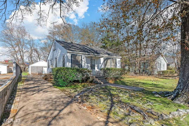 bungalow-style house with an outbuilding, a garage, and a front yard