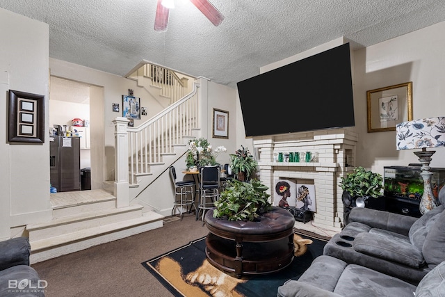 carpeted living room with ceiling fan, a textured ceiling, and a fireplace