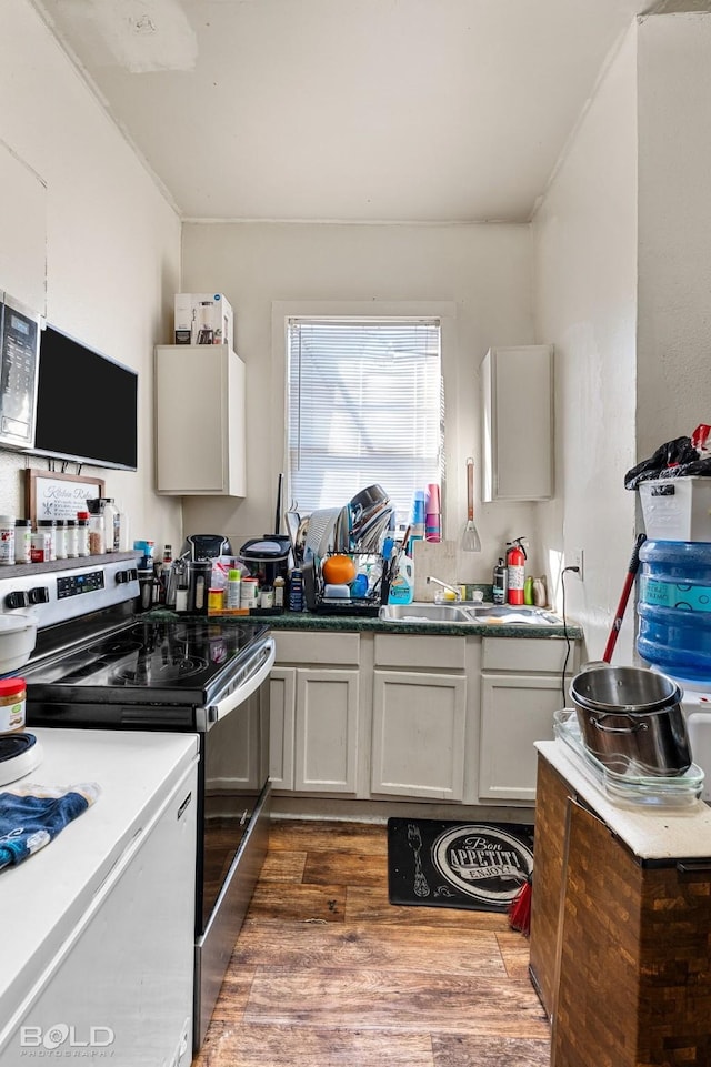 kitchen featuring stainless steel range with electric stovetop, dark hardwood / wood-style floors, and white cabinets