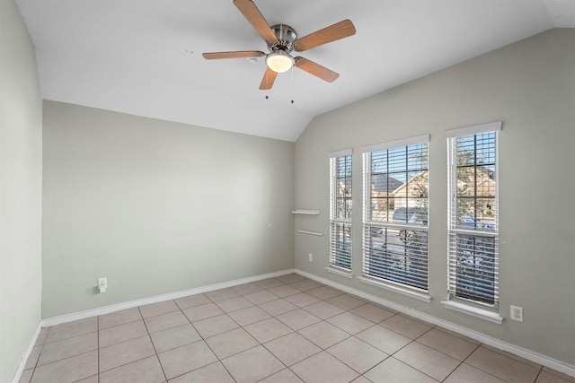 empty room with light tile patterned floors, baseboards, vaulted ceiling, and a ceiling fan