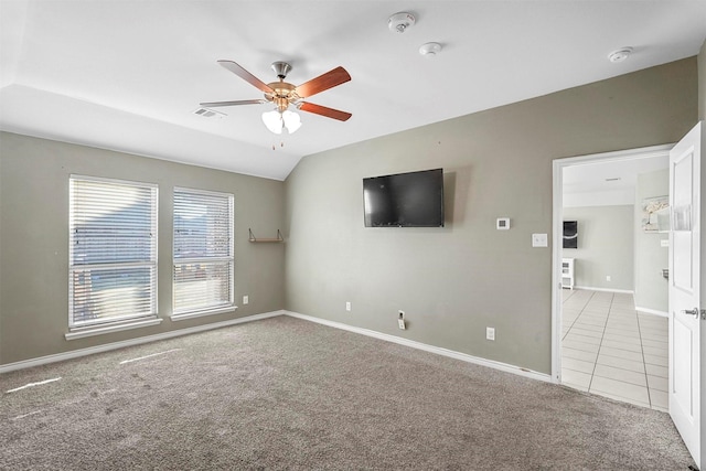 spare room featuring lofted ceiling, ceiling fan, visible vents, baseboards, and carpet