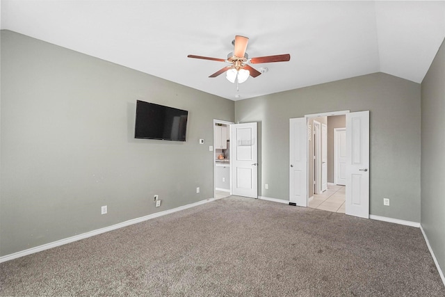 unfurnished bedroom with light carpet, ceiling fan, baseboards, and vaulted ceiling