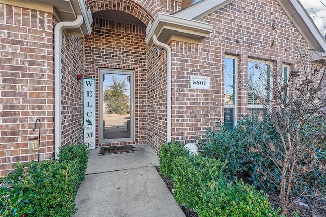 property entrance featuring brick siding