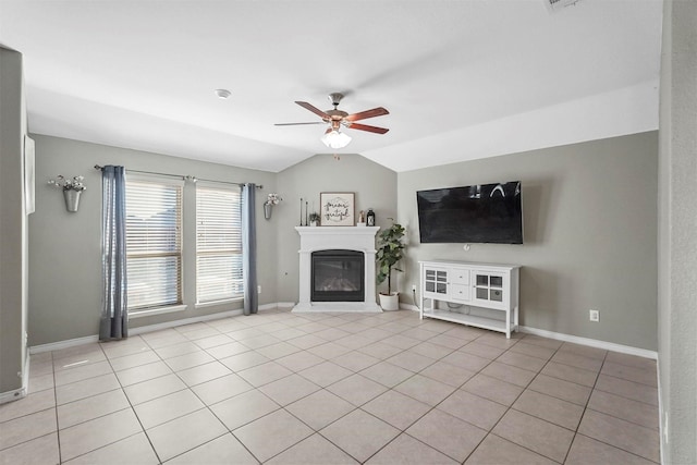 unfurnished living room featuring light tile patterned floors, lofted ceiling, a ceiling fan, a glass covered fireplace, and baseboards