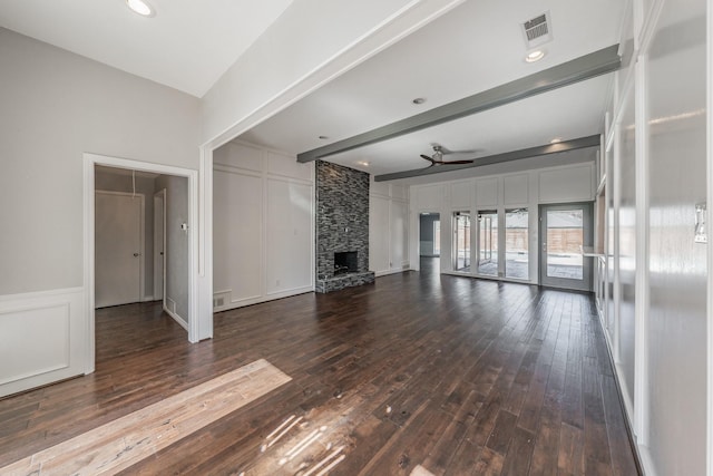 unfurnished living room with dark wood-type flooring, a fireplace, beam ceiling, and ceiling fan