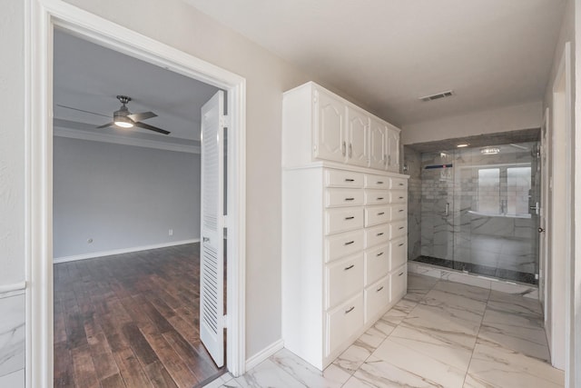 bathroom featuring a shower with door, crown molding, and ceiling fan