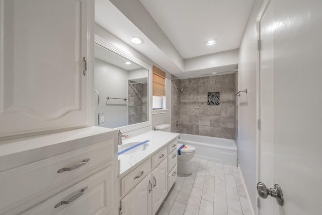 full bathroom featuring tiled shower / bath combo, vanity, and toilet