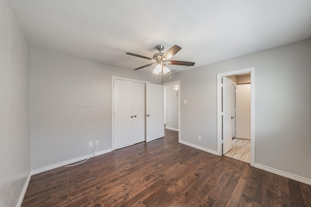 unfurnished bedroom featuring dark hardwood / wood-style floors, ceiling fan, and a closet