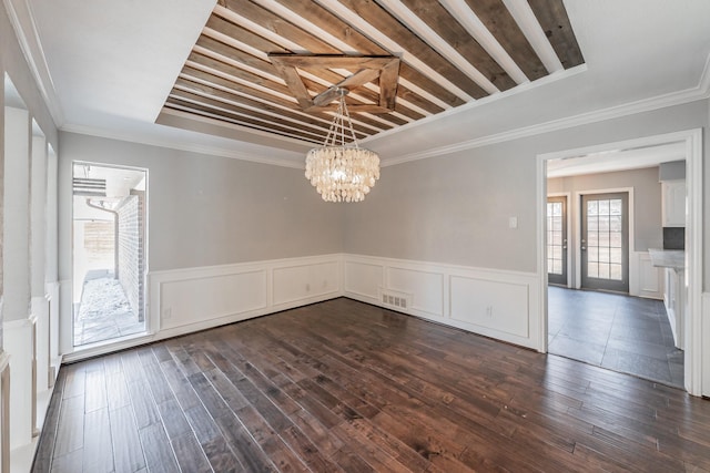 unfurnished dining area with ornamental molding, dark hardwood / wood-style floors, and an inviting chandelier