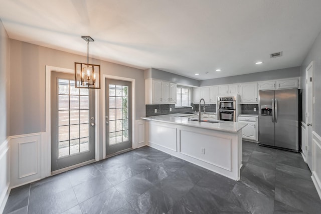 kitchen with stainless steel appliances, sink, white cabinets, and kitchen peninsula