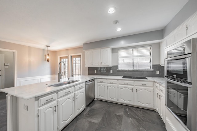 kitchen featuring sink, hanging light fixtures, stainless steel appliances, white cabinets, and kitchen peninsula