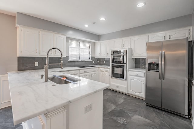 kitchen featuring white cabinetry, sink, stainless steel appliances, and kitchen peninsula