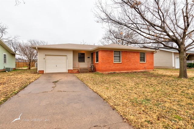 ranch-style home with central AC unit, a garage, and a front yard