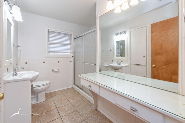 bathroom featuring toilet, a shower with shower door, tile patterned flooring, and tile walls