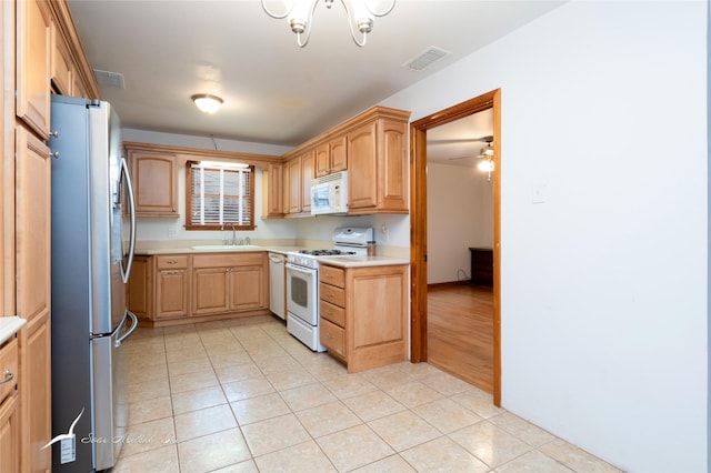 kitchen with ceiling fan, sink, light tile patterned floors, and white appliances