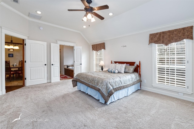 carpeted bedroom featuring vaulted ceiling, ceiling fan with notable chandelier, connected bathroom, and crown molding