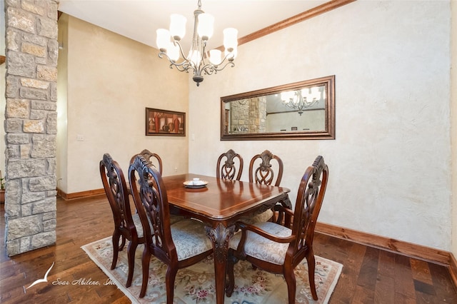 dining area featuring ornate columns, dark wood-type flooring, and an inviting chandelier