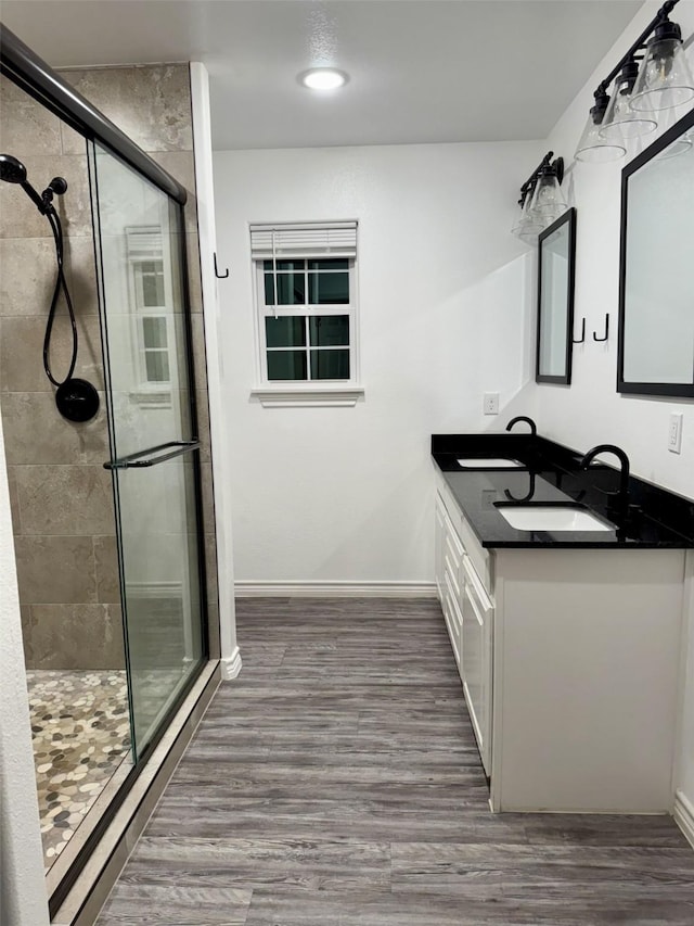 bathroom featuring hardwood / wood-style flooring, vanity, and an enclosed shower