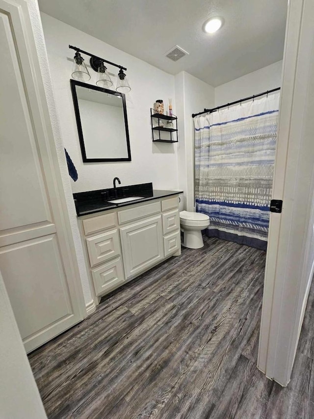 bathroom with hardwood / wood-style flooring, vanity, and toilet